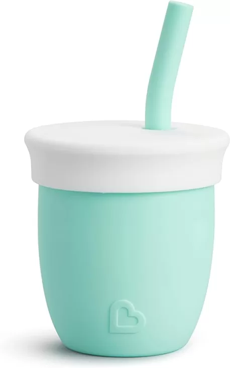 A small mint green silicone cup with a white silicone lid and a silicone straw.